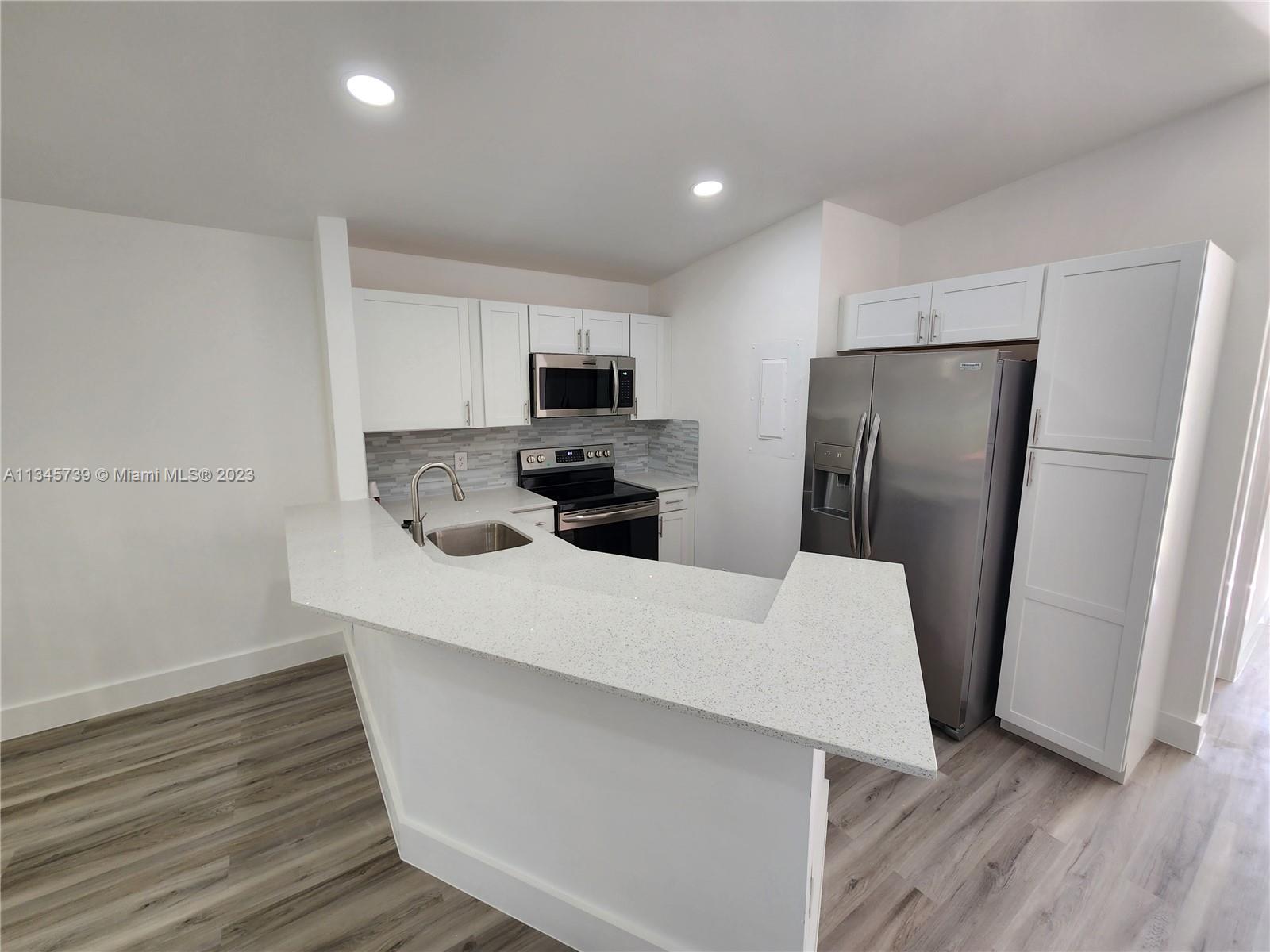 a kitchen with stainless steel appliances a refrigerator stove microwave and sink