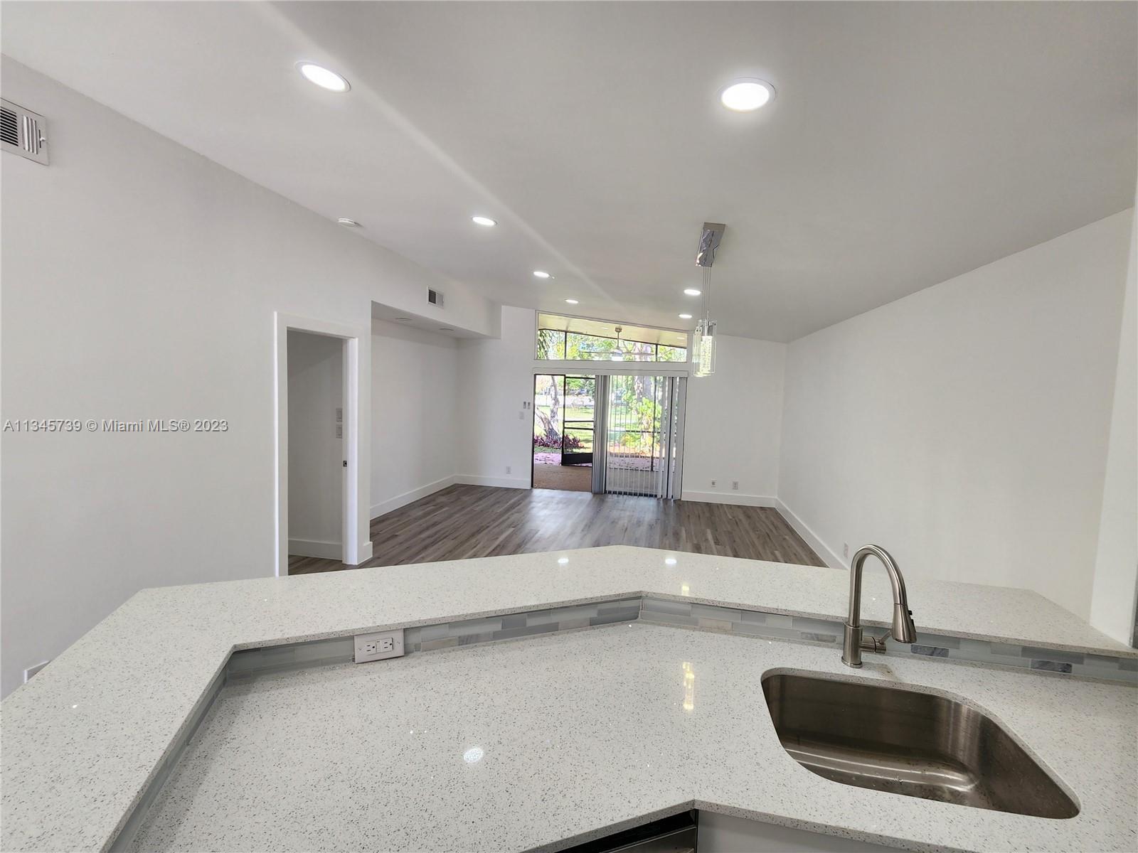 11603 Timbers Way Boca Raton, FL 33428 - Photo 21 of 48 a kitchen with a sink and chandelier