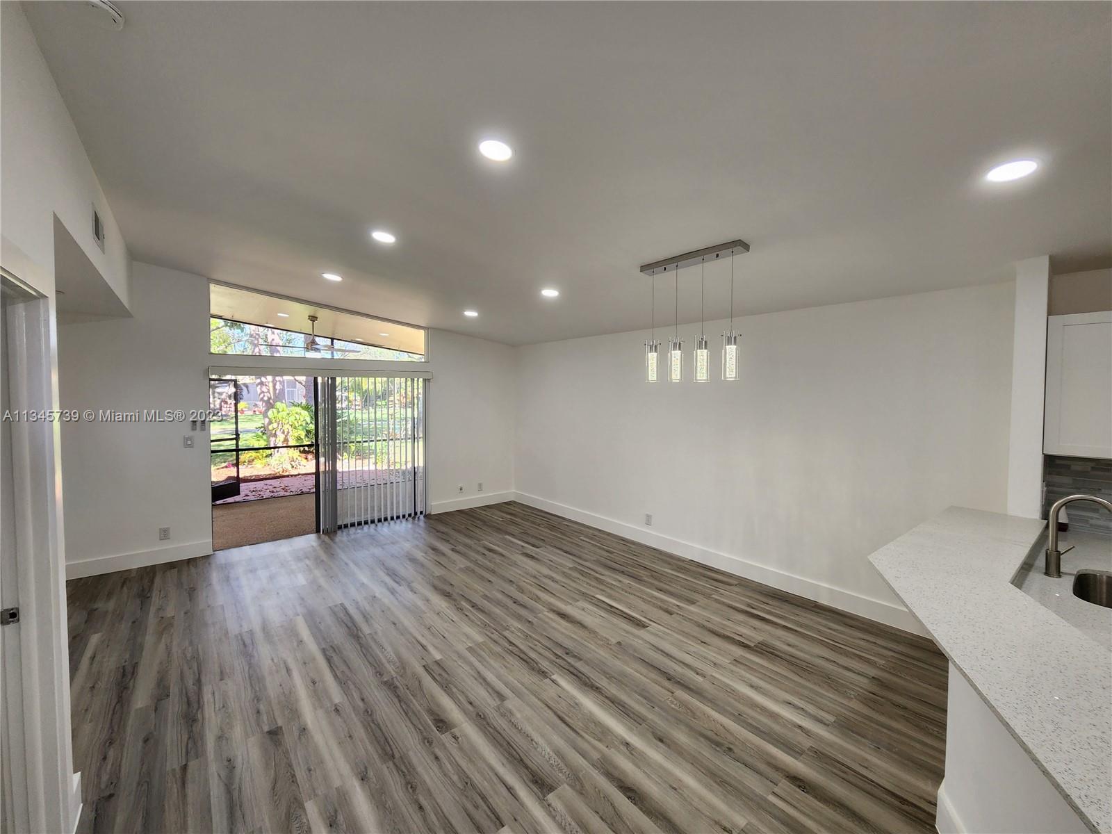 11603 Timbers Way Boca Raton, FL 33428 - Photo 22 of 48 a view of an empty room with wooden floor and a window