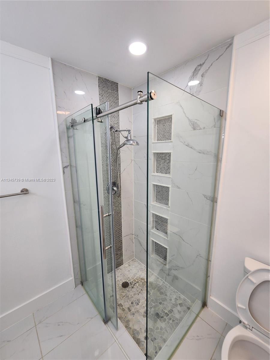 11603 Timbers Way Boca Raton, FL 33428 - Photo 31 of 48 a bathroom with a glass door shower a toilet and a sink