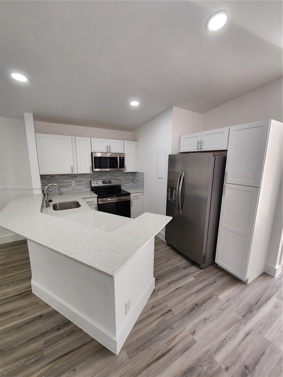 11603 Timbers Way Boca Raton, FL 33428 - Photo 4 of 48 a large kitchen with stainless steel appliances a refrigerator and a stove top oven