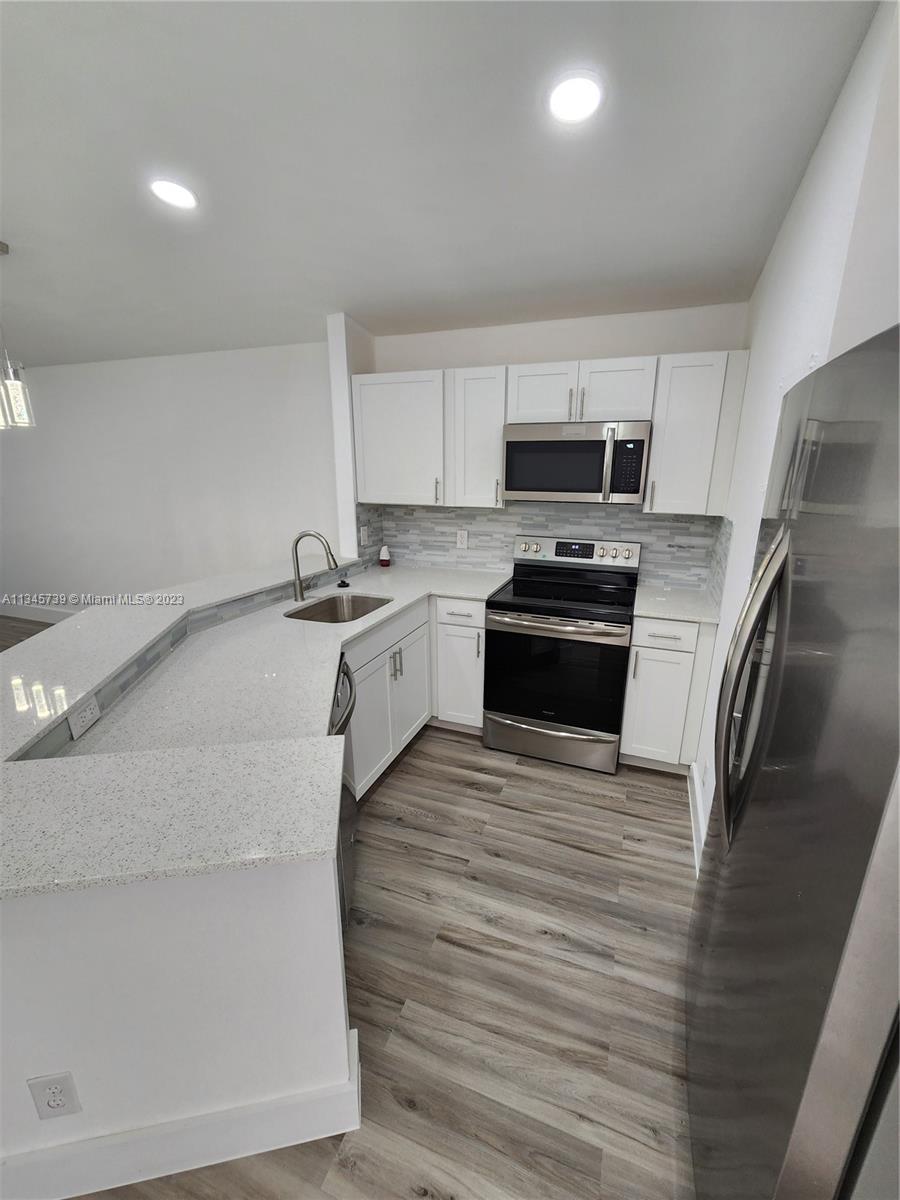 11603 Timbers Way Boca Raton, FL 33428 - Photo 5 of 48 a kitchen with granite countertop a sink stove and refrigerator