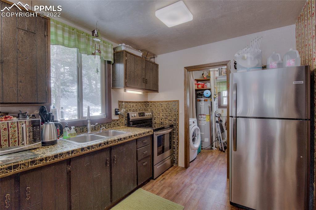 176 Cheyenne Road Alma, CO 80420 - Photo 17 of 50 a kitchen with a refrigerator a sink and dishwasher wooden cabinets with a large window