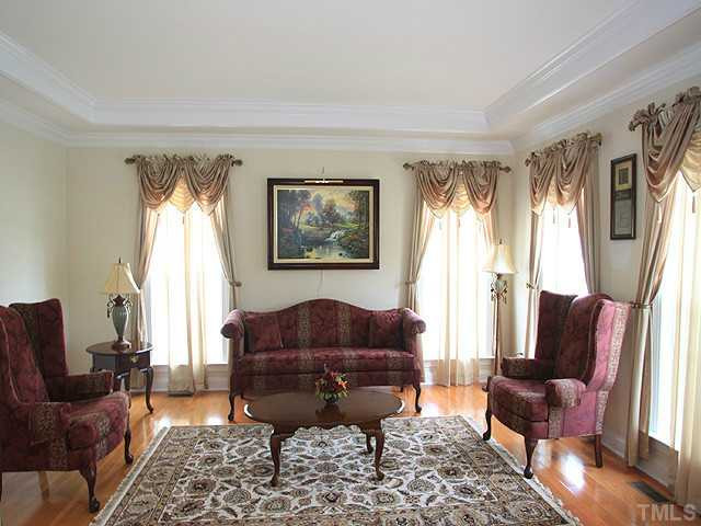 212 Quarryrock Road Holly Springs, NC 27540 - Photo 6 of 25 The formal living room has large windows and continuation of the hardwoods from the foyer. Living Room