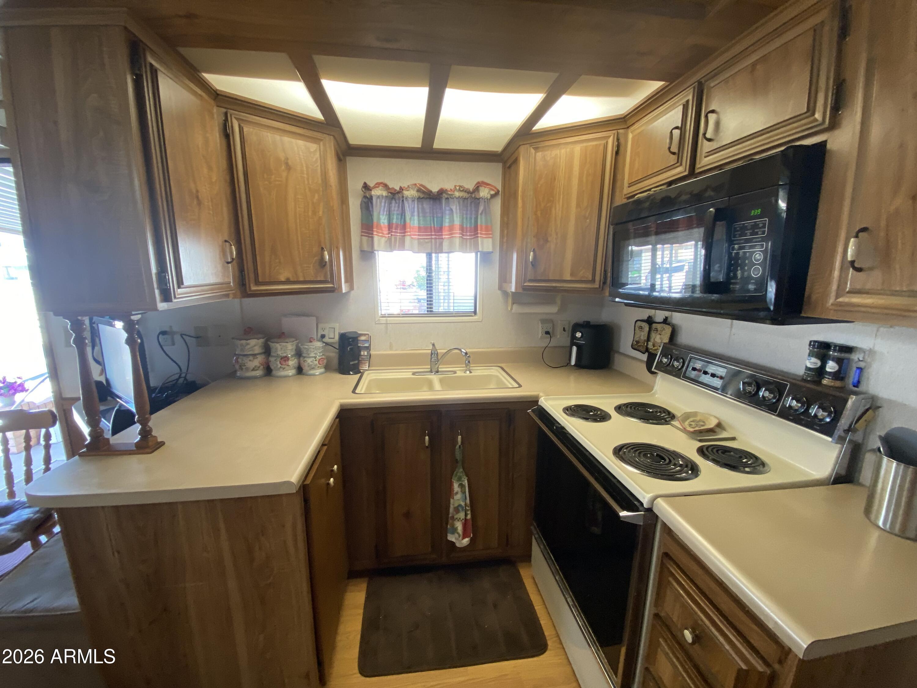 1328 West Inuit Avenue Apache Junction, AZ 85119 - Photo 2 of 45 a kitchen that has a sink and a stove in it