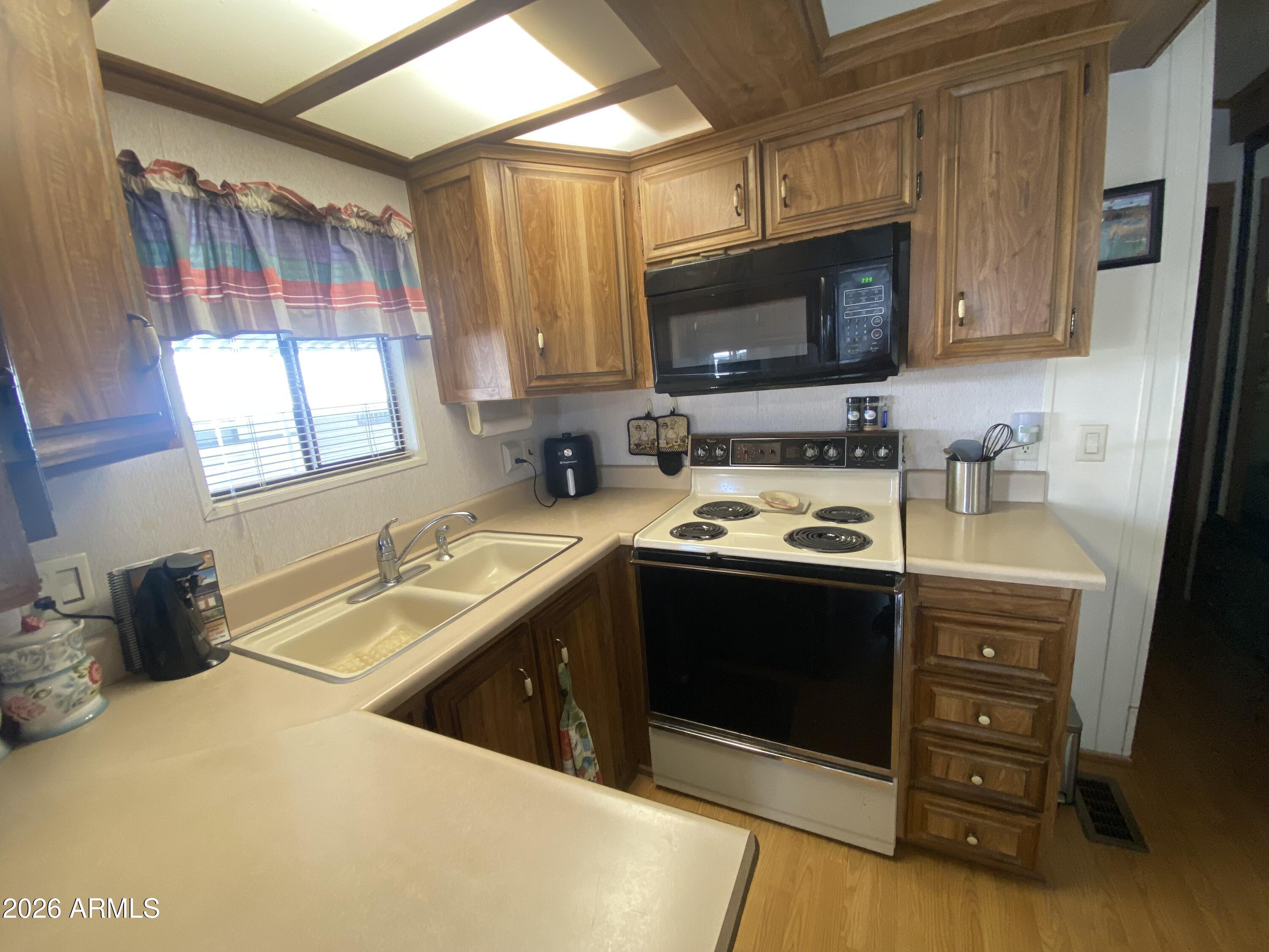 1328 West Inuit Avenue Apache Junction, AZ 85119 - Photo 3 of 45 a kitchen with a sink stove and microwave