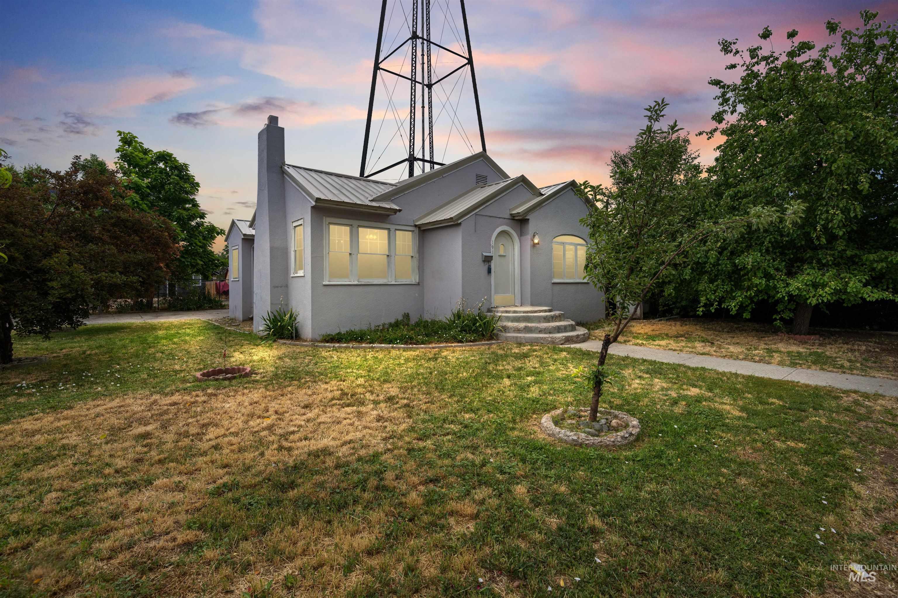 191 Southwest 5th Avenue Ontario, OR 97914 - Photo 1 of 50 View of front of house featuring a chimney, a yard, stucco siding, a metal roof, and a standing seam roof