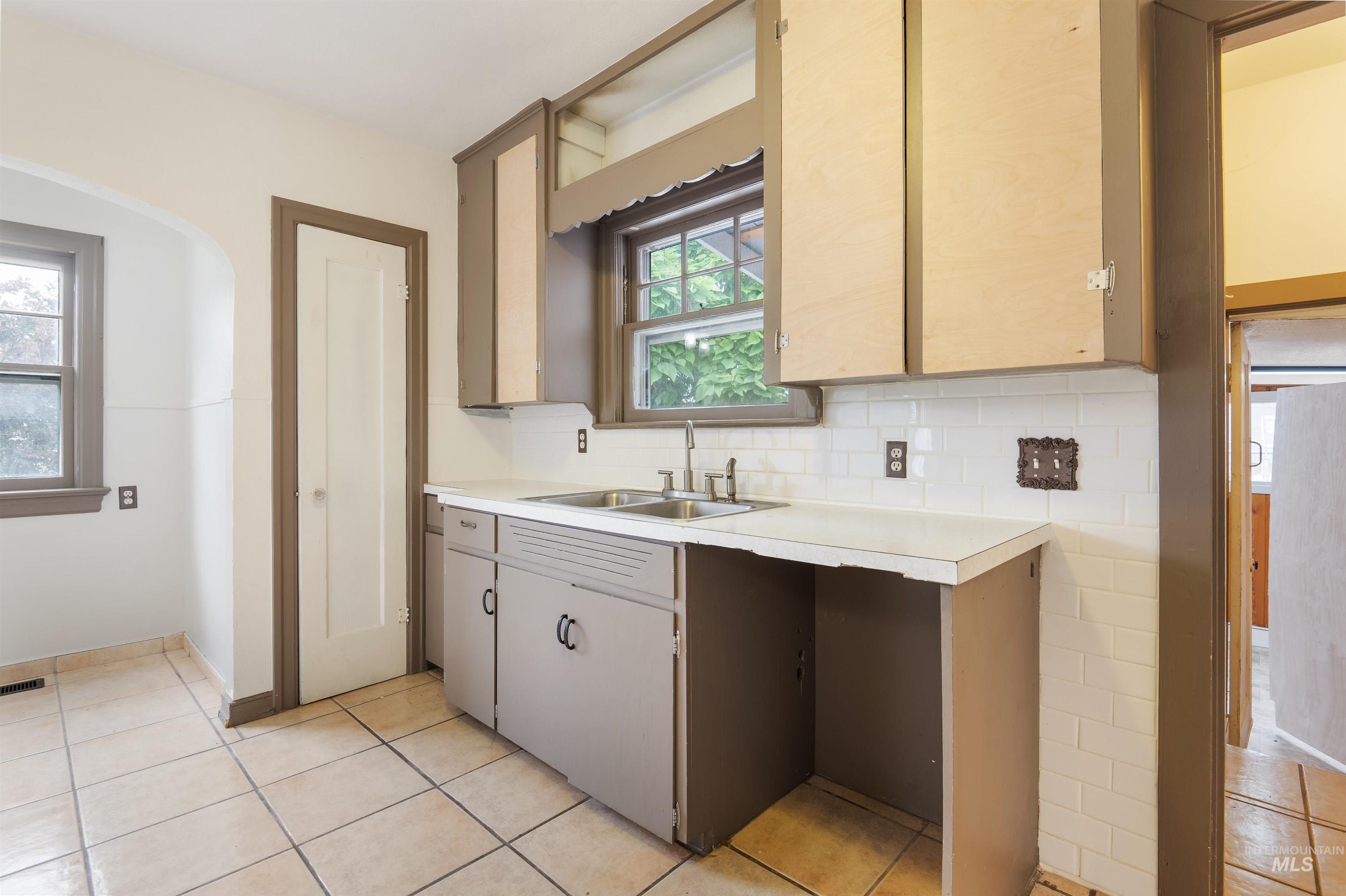 191 Southwest 5th Avenue Ontario, OR 97914 - Photo 18 of 50 Kitchen with light countertops, light tile patterned floors, arched walkways, and tasteful backsplash