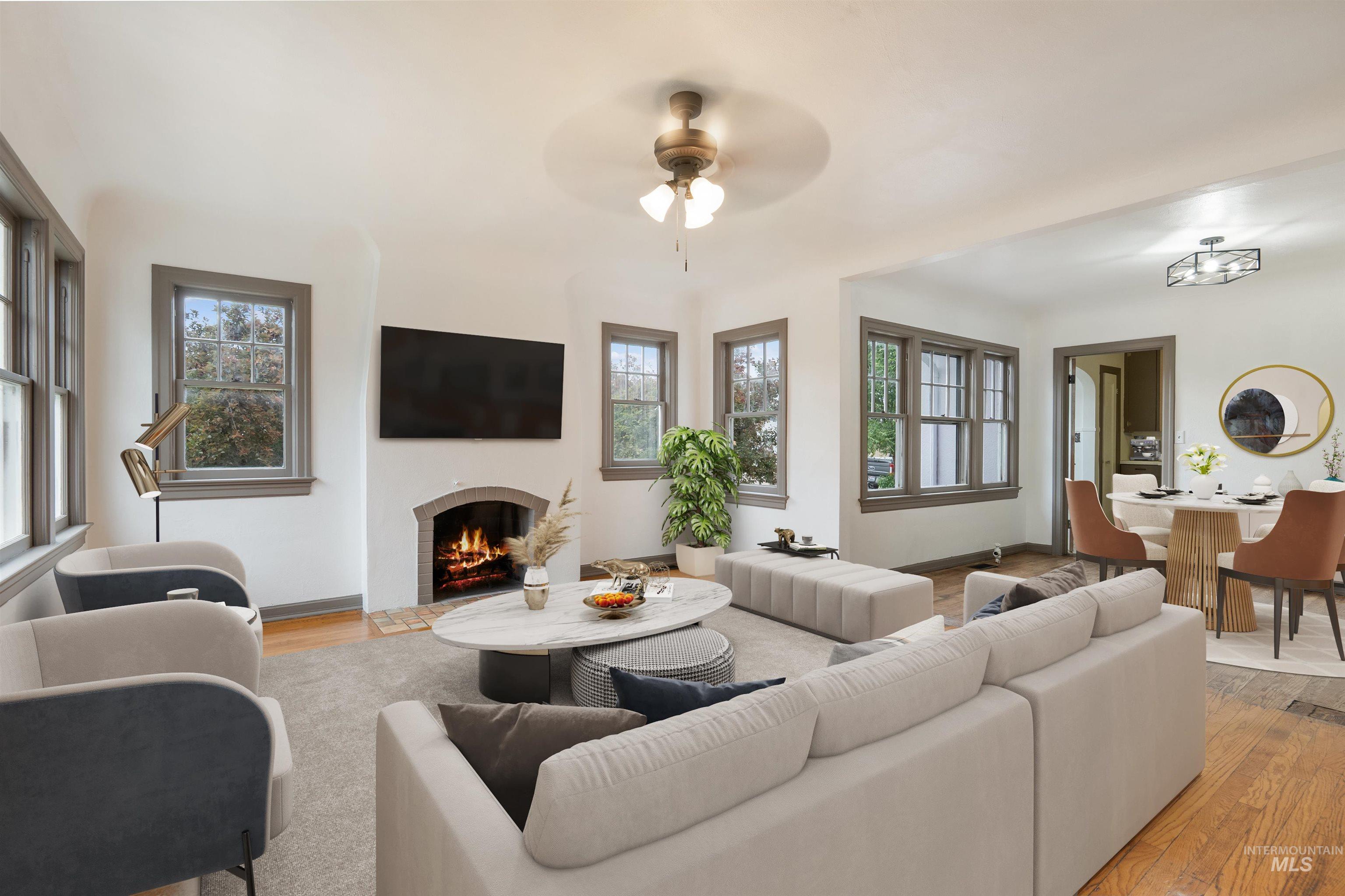 191 Southwest 5th Avenue Ontario, OR 97914 - Photo 47 of 50 Living area featuring light wood finished floors, a ceiling fan, and a warm lit fireplace