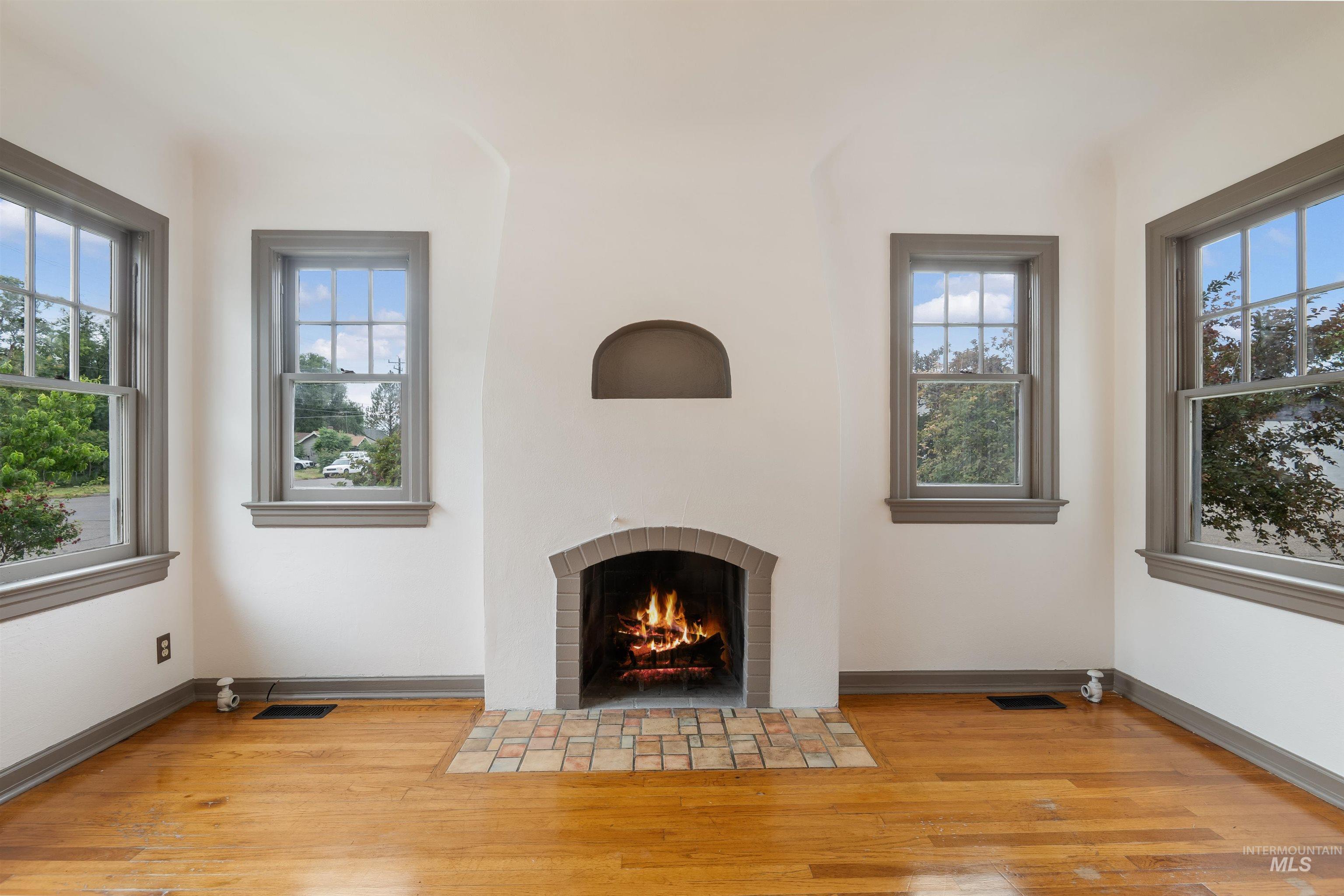 191 Southwest 5th Avenue Ontario, OR 97914 - Photo 8 of 50 Unfurnished living room with light wood finished floors, a brick fireplace, and healthy amount of natural light