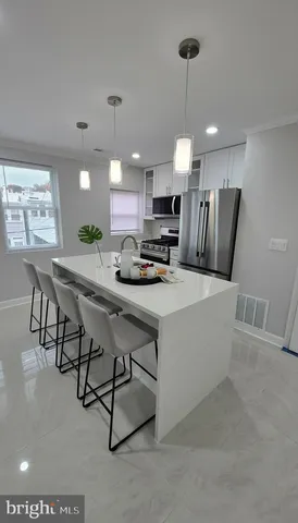 a kitchen with kitchen island stainless steel appliances a center island a stove a dining table and chairs