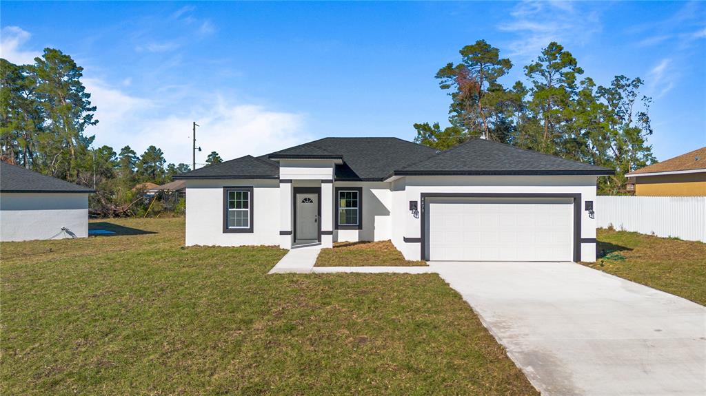 4479 Southwest 170th Street Road Ocala, FL 34473 - Photo 1 of 1 a front view of a house with a yard and garage