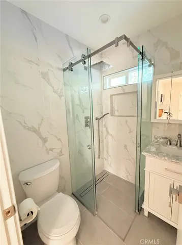 a bathroom with a granite countertop toilet sink and shower