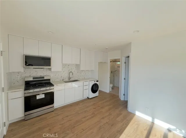 a kitchen with white cabinets and stainless steel appliances
