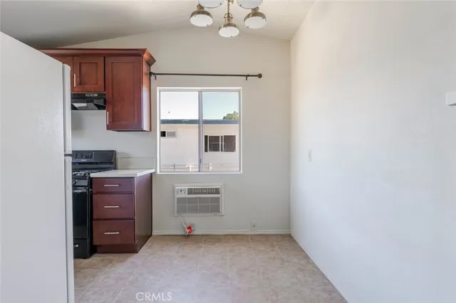 a kitchen with a refrigerator and a stove top oven