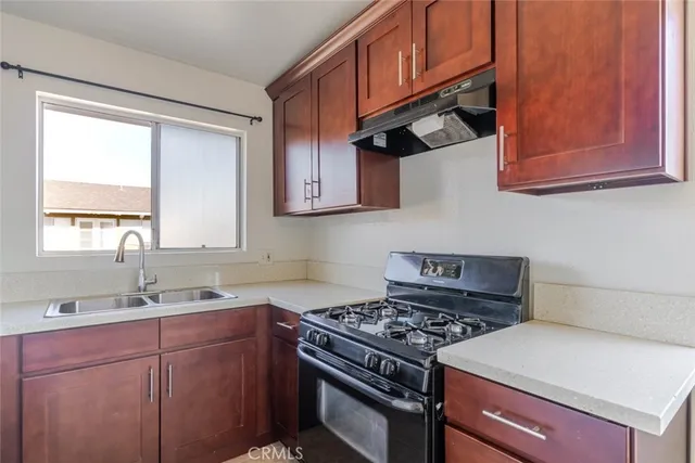 a kitchen with stainless steel appliances granite countertop a sink stove top oven and cabinets