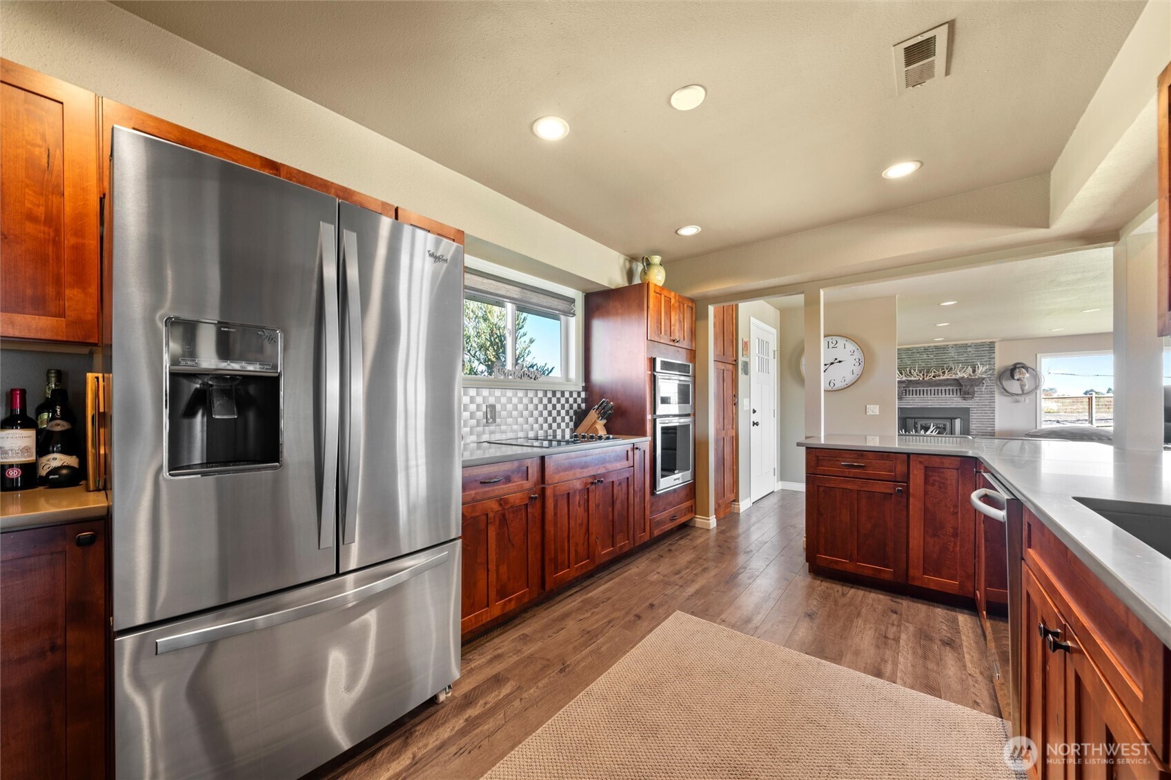 8708 Rd K Northeast Moses Lake, WA 98837 - Photo 10 of 40 a kitchen with stainless steel appliances granite countertop a refrigerator a sink dishwasher a oven with wooden cabinets and wooden floor