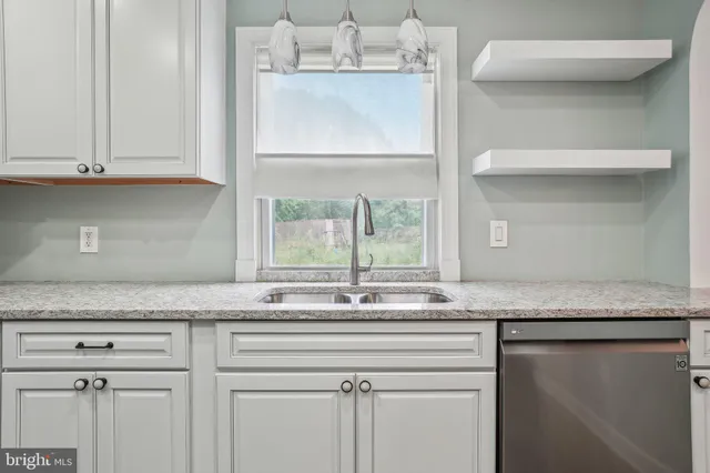 a kitchen with granite countertop a sink and cabinets