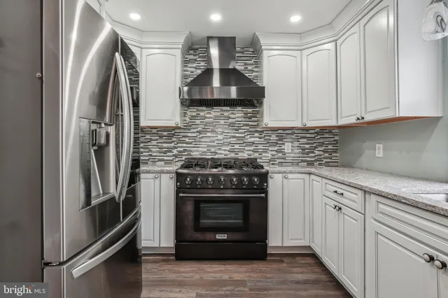 a kitchen with stainless steel appliances granite countertop a refrigerator and a stove