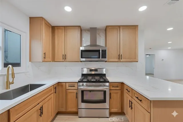 a kitchen with granite countertop white cabinets and stainless steel appliances