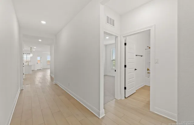 a view of a hallway with wooden floor