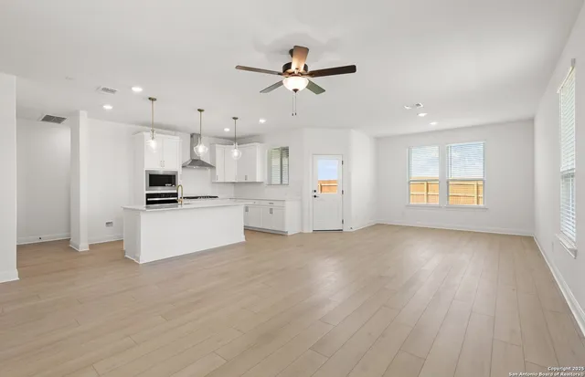 a view of an empty room with kitchen appliances and a window