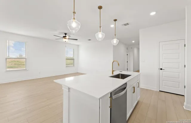 a kitchen that has a sink a stove and a wooden floor
