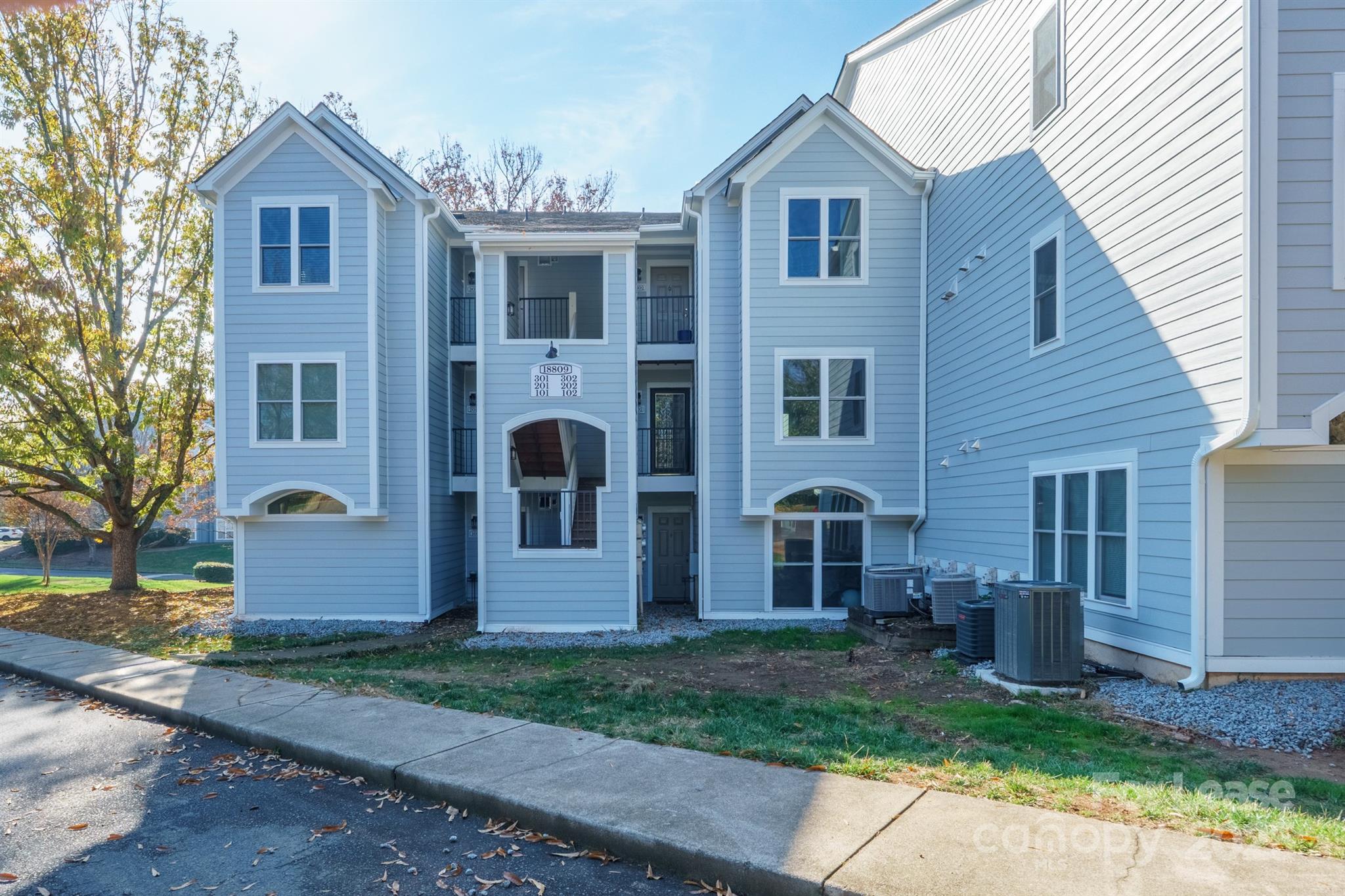 18809 Nautical Drive, Unit 202 Cornelius, NC 28031 - Photo 1 of 32 a front view of a house with a yard and garage