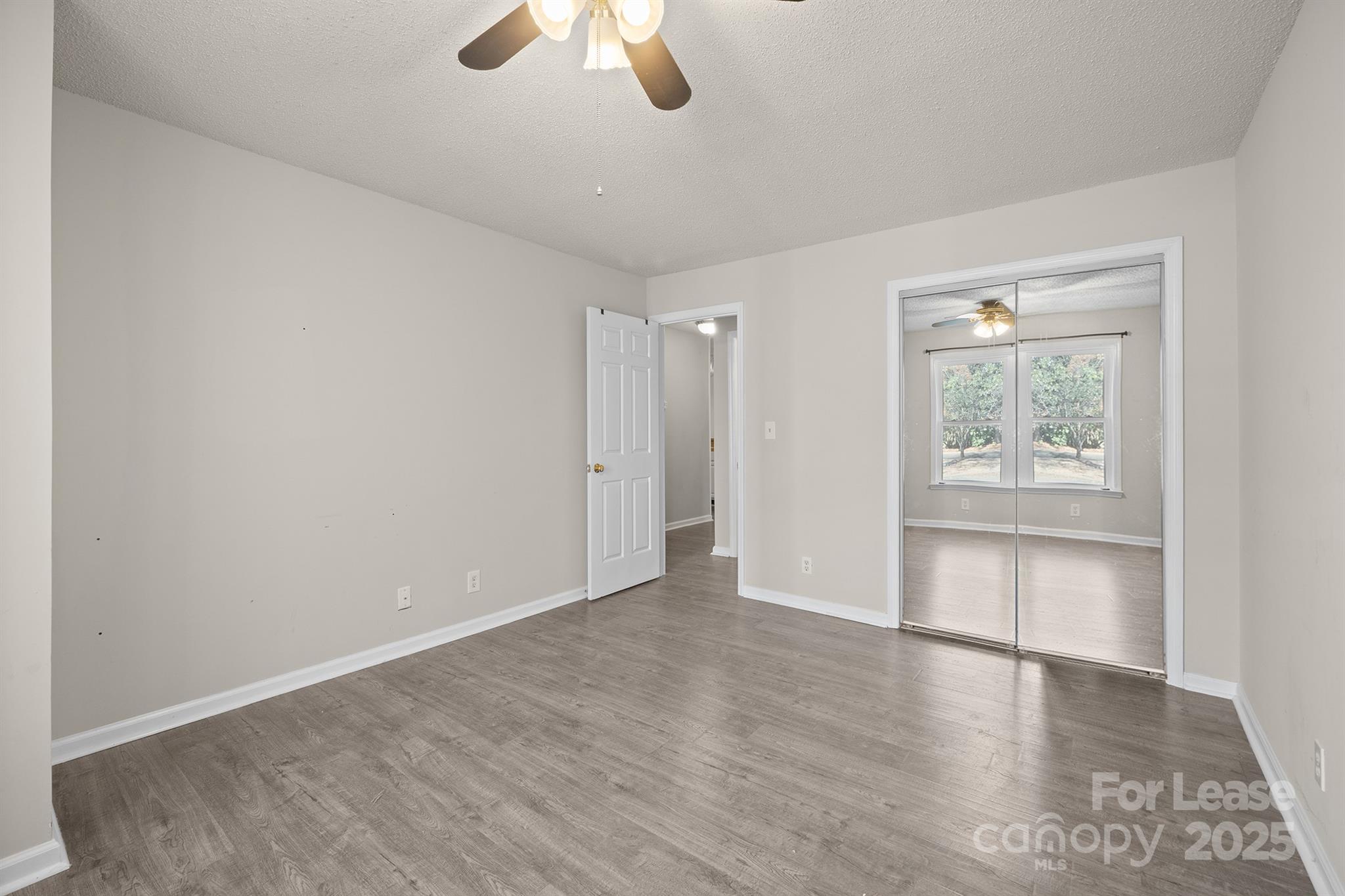 18809 Nautical Drive, Unit 202 Cornelius, NC 28031 - Photo 13 of 32 an empty room with windows and ceiling fan