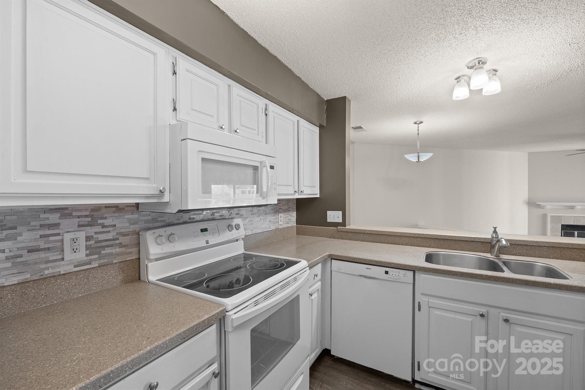 18809 Nautical Drive, Unit 202 Cornelius, NC 28031 - Photo 25 of 32 a kitchen that has a sink and a stove
