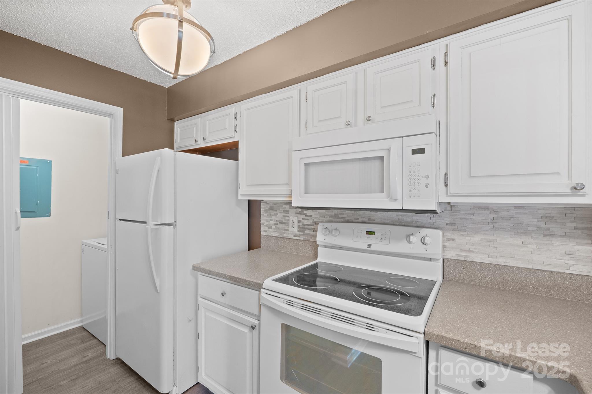 18809 Nautical Drive, Unit 202 Cornelius, NC 28031 - Photo 26 of 32 a kitchen with white cabinets and white appliances