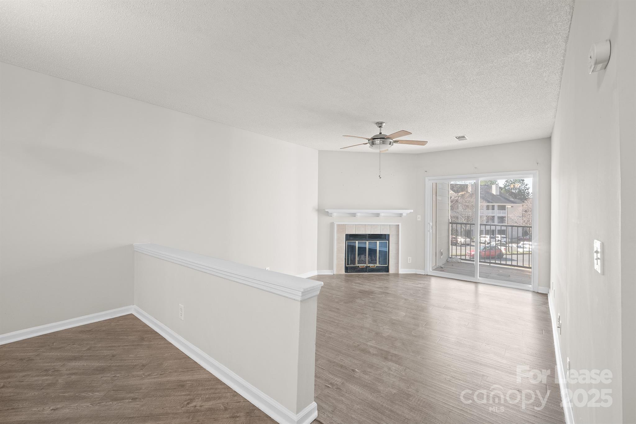 18809 Nautical Drive, Unit 202 Cornelius, NC 28031 - Photo 28 of 32 a view of a livingroom with wooden floor and a kitchen