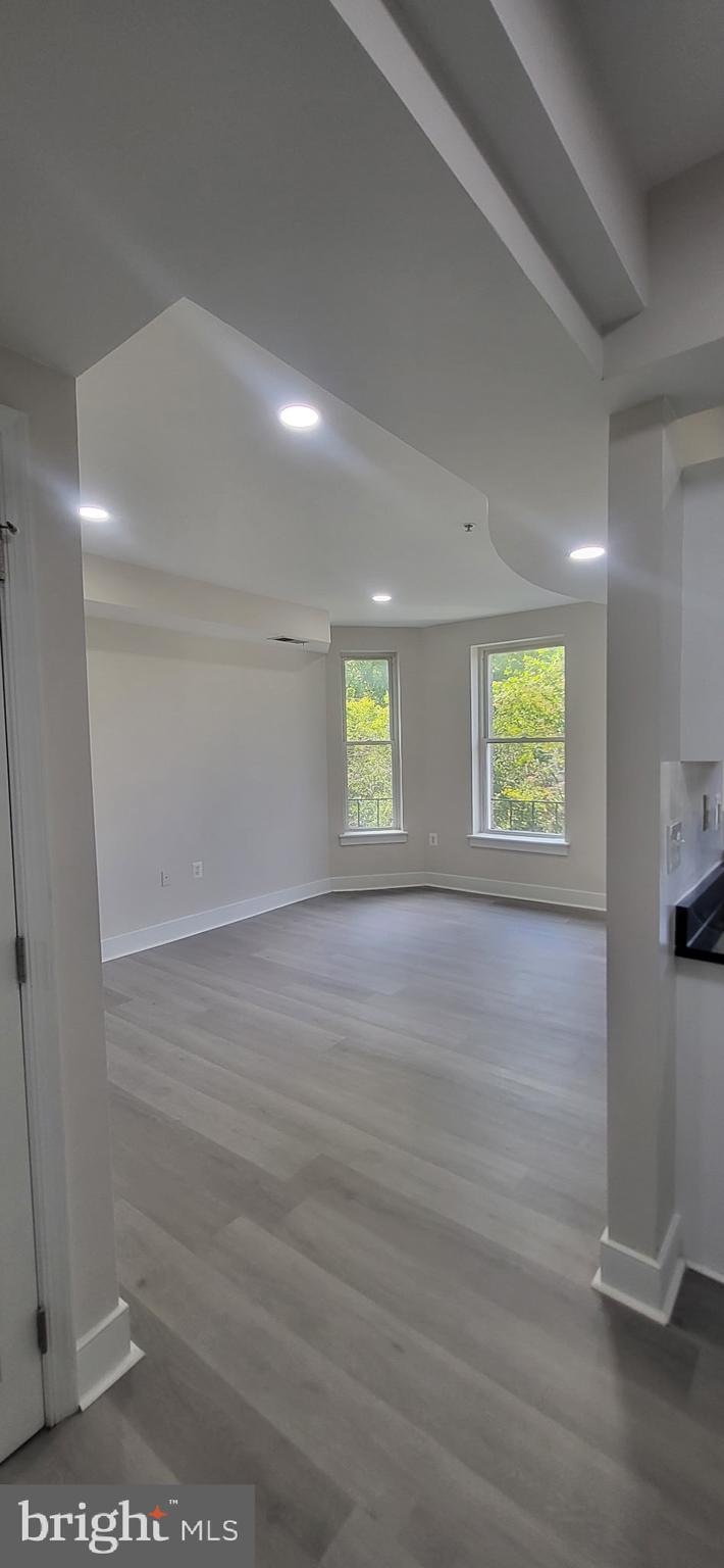 1108 Columbia Road Northwest, Unit 202 Washington, DC 20009 - Photo 11 of 19 an empty room with wooden floor and windows