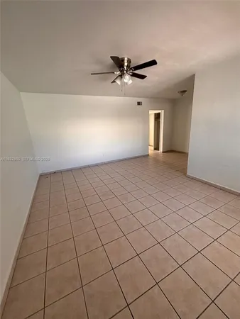 an empty room with windows and ceiling fan