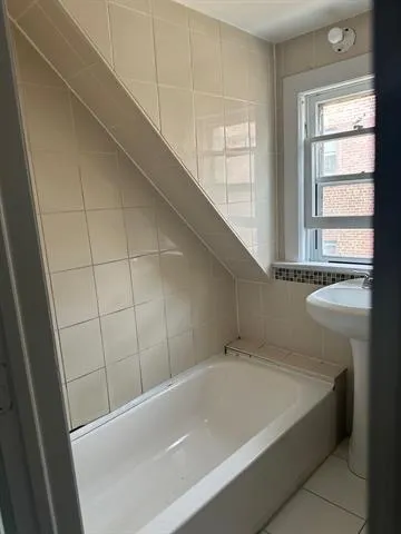 a bathroom with a bathtub and a window