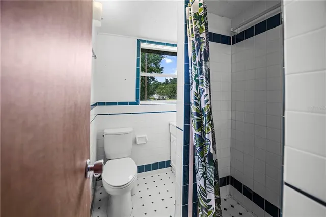 a bathroom with a toilet and a shower