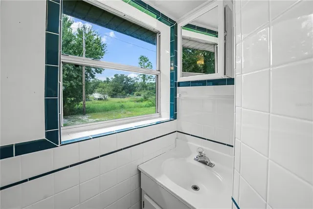 a bathroom with a sink mirror and window