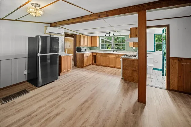 a kitchen with stainless steel appliances wooden floor and large window