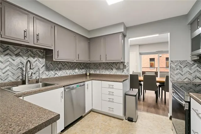 a kitchen with granite countertop white cabinets and stainless steel appliances