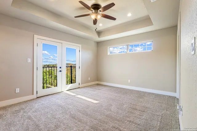 an empty room with windows and ceiling fan
