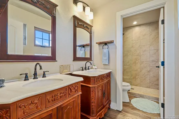 a bathroom with a granite countertop sink a toilet a mirror and shower