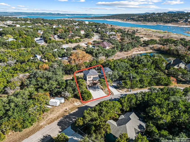 an aerial view of a residential houses with outdoor space and trees