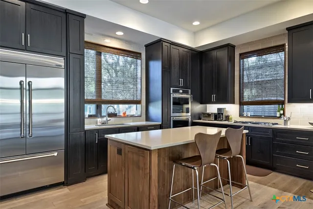 a large kitchen with lots of counter space and stainless steel appliances