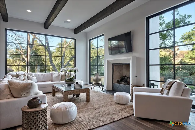 a living room with furniture a fireplace and a large window