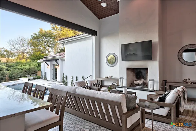 a living room with furniture a fireplace and a floor to ceiling window