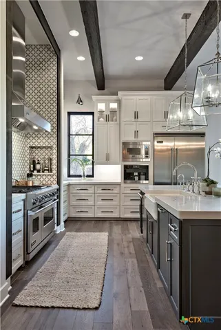 a kitchen with stainless steel appliances granite countertop a stove and cabinets