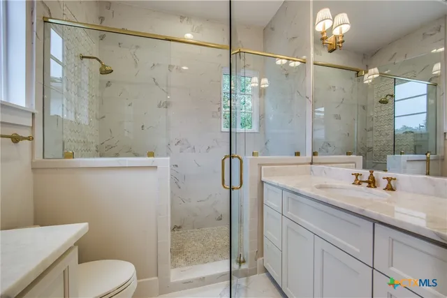 a bathroom with a granite countertop sink toilet and shower