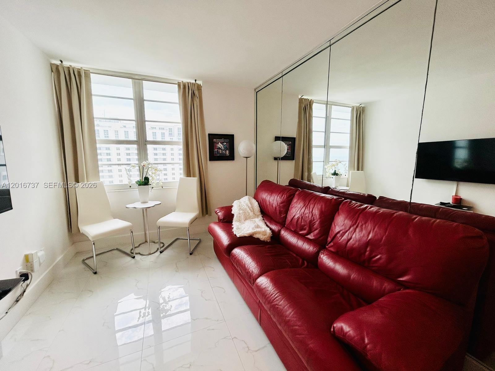 100 Lincoln Road, Unit 1526 Miami Beach, FL 33139 - Photo 2 of 9 a living room with furniture and a flat screen tv