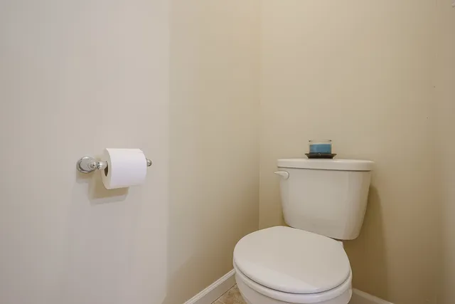 a spacious bathroom with a granite countertop sink a toilet and a mirror