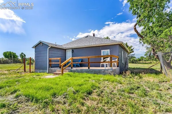 a view of a house with a yard and sitting area